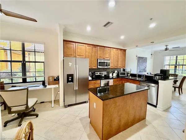 a kitchen with stainless steel appliances granite countertop a refrigerator a sink a stove and a cabinets