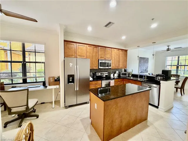a kitchen with stainless steel appliances granite countertop a refrigerator a sink a stove and a cabinets