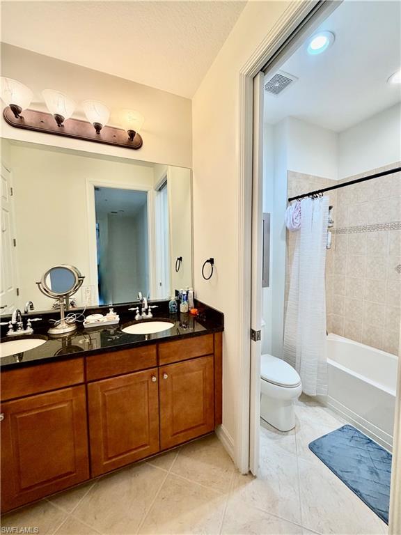 9109 Yuba Lane, Unit 80 Naples, FL 34113 - Photo 8 of 15 a spacious bathroom with a granite countertop sink toilet mirror and a bathtub