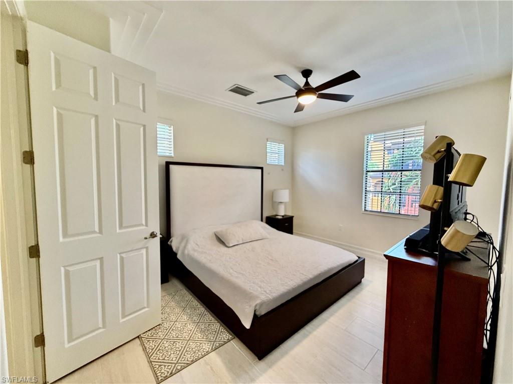 9109 Yuba Lane, Unit 80 Naples, FL 34113 - Photo 9 of 15 a bedroom with a bed and wooden floor