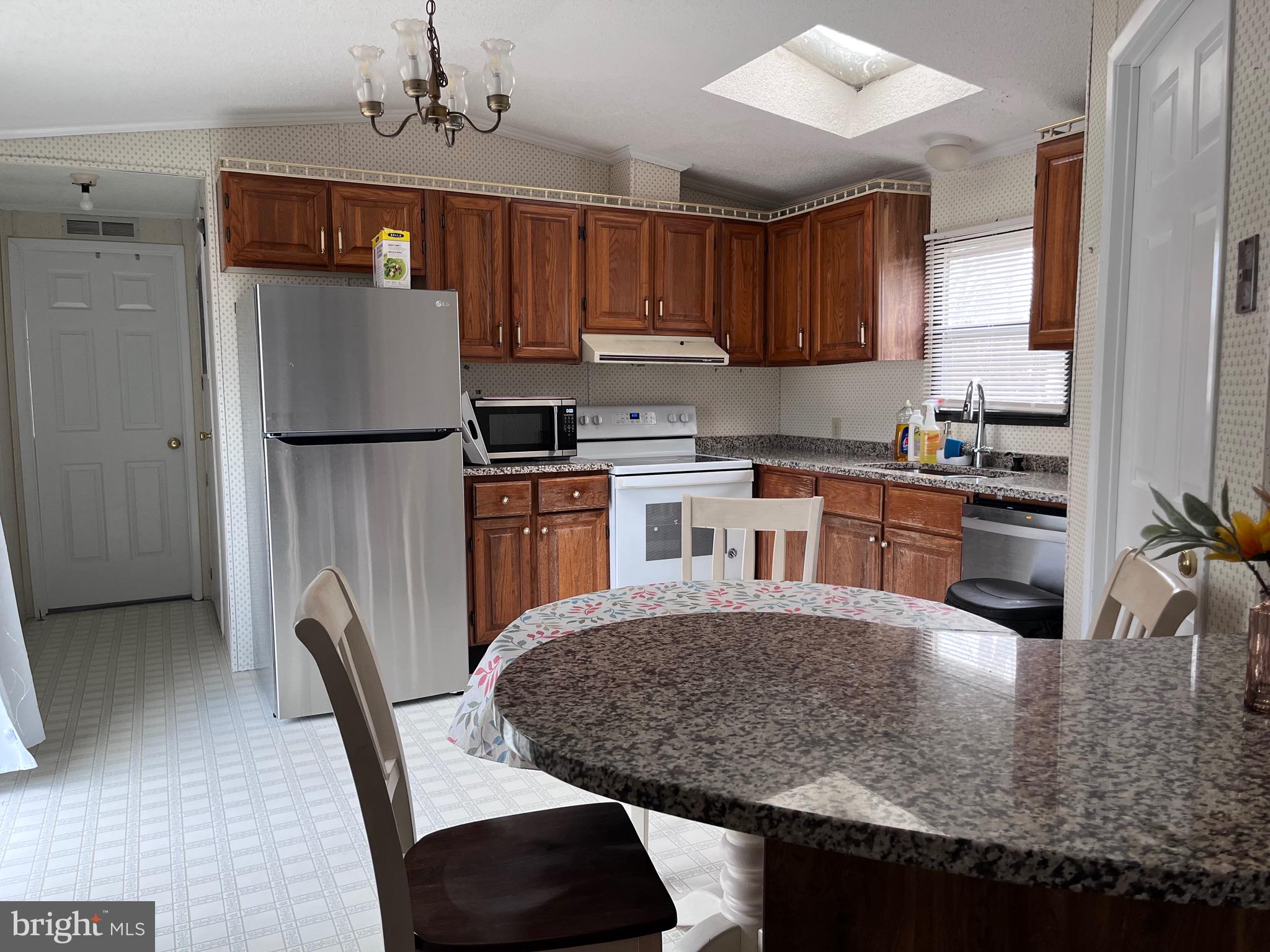 8 Merganser Road Georgetown, DE 19947 - Photo 3 of 13 a kitchen with kitchen island a counter top space cabinets and stainless steel appliances