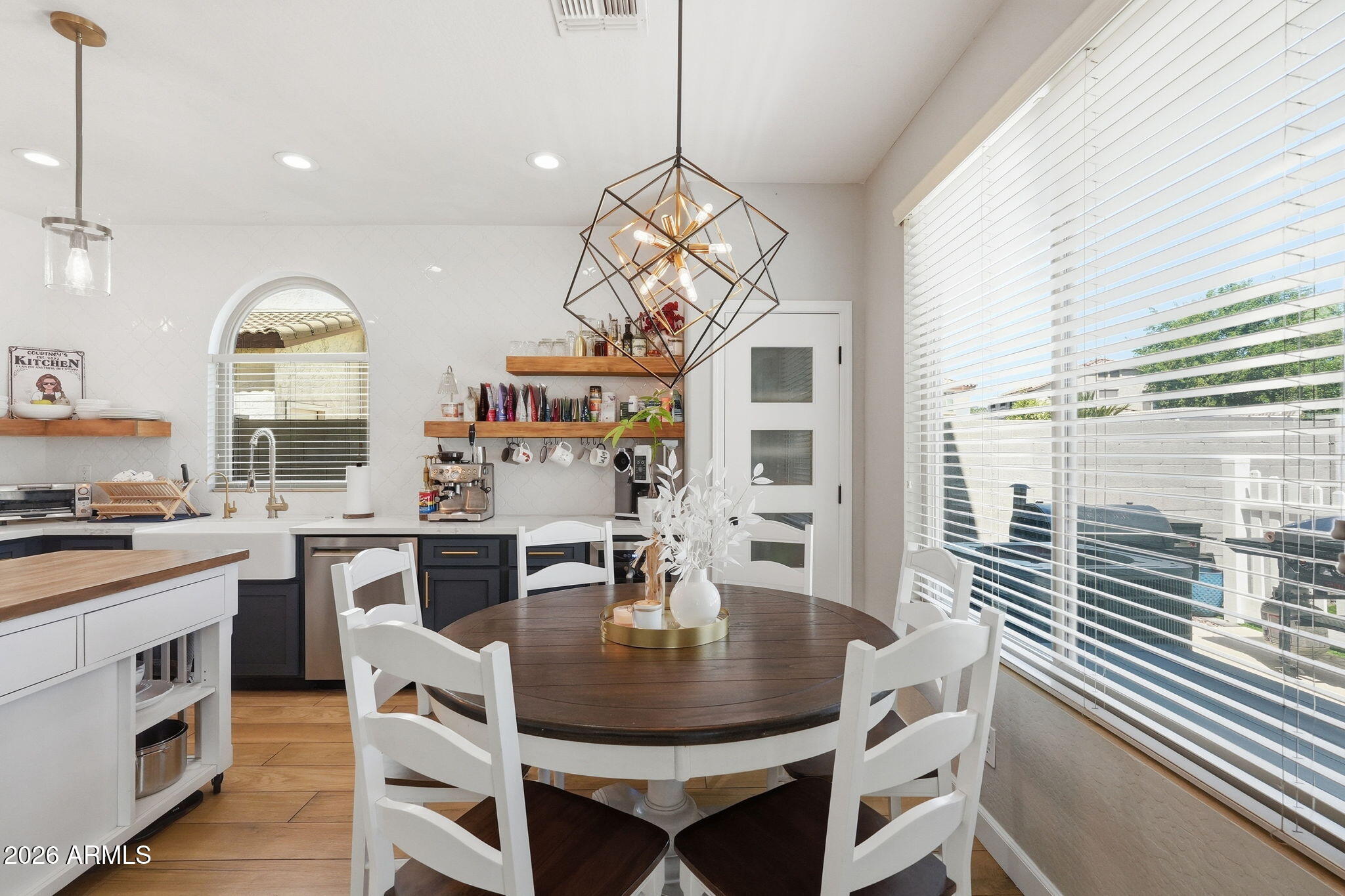 4184 East Trigger Way Gilbert, AZ 85297 - Photo 15 of 51 a dining room with wooden floor a chandelier a wooden table and chairs