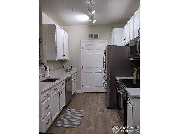 a kitchen with granite countertop a refrigerator stove and sink