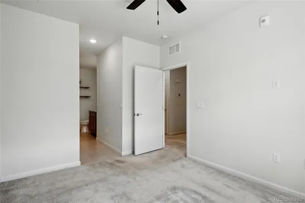 an empty room with a ceiling fan and entryway
