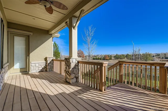 a view of a balcony with wooden floor and fence