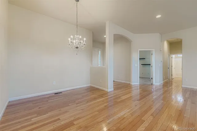 a view of a room with wooden floor and chandelier