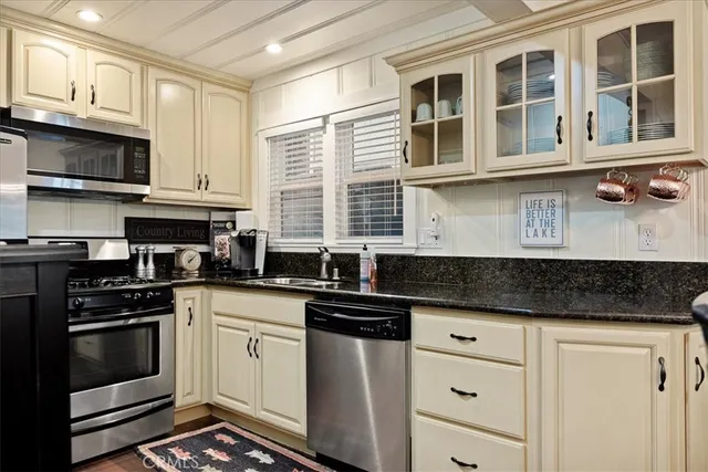 a kitchen with stainless steel appliances granite countertop a stove and white cabinets