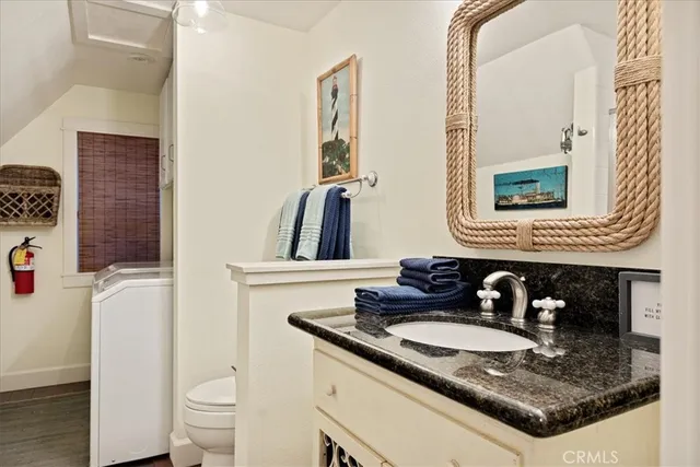 a bathroom with a granite countertop sink a toilet and a mirror