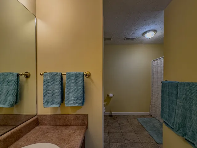 a bathroom with a granite countertop toilet and a sink