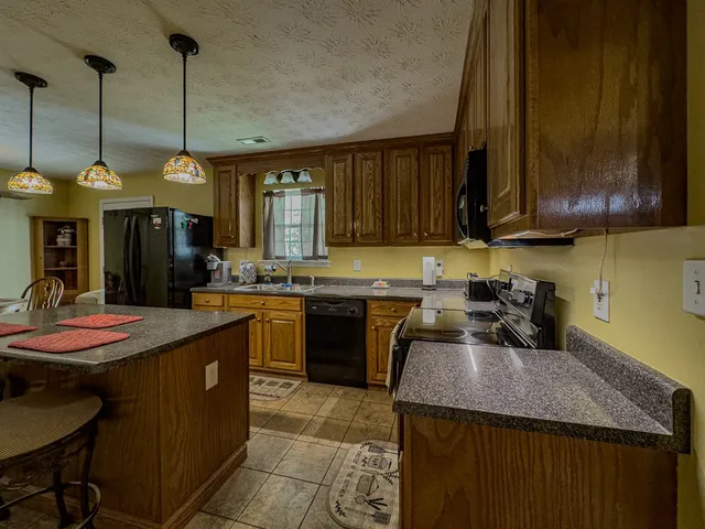 a kitchen with stainless steel appliances granite countertop a stove refrigerator and wooden floor