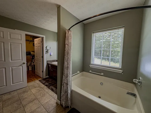 a kitchen with stainless steel appliances granite countertop a refrigerator a stove a sink a dining table and chairs