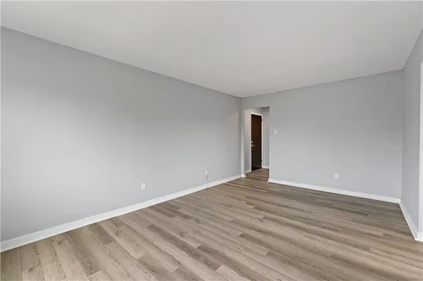 a view of an empty room with wooden floor