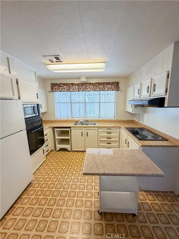 a kitchen with a sink appliances and cabinets