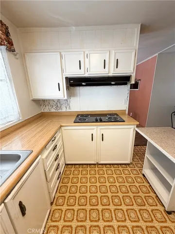 a view of a refrigerator with wooden cabinets
