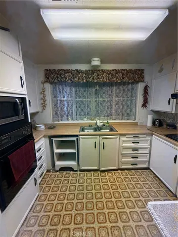 a kitchen with a stove and white cabinets