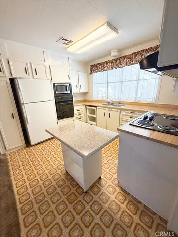 a kitchen with a stove a sink and a refrigerator