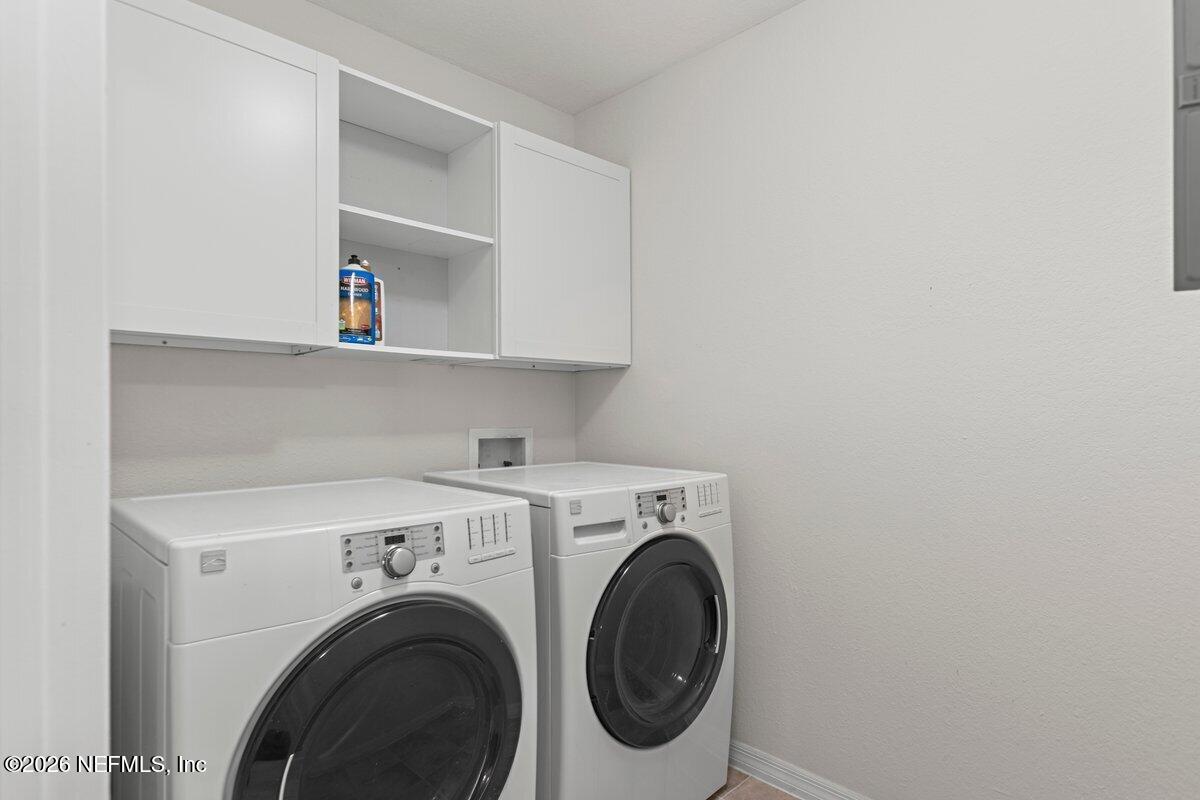 10961 Burnt Mill Road, Unit 333 Jacksonville, FL 32256 - Photo 15 of 21 a view of washer and dryer with wooden cabinets