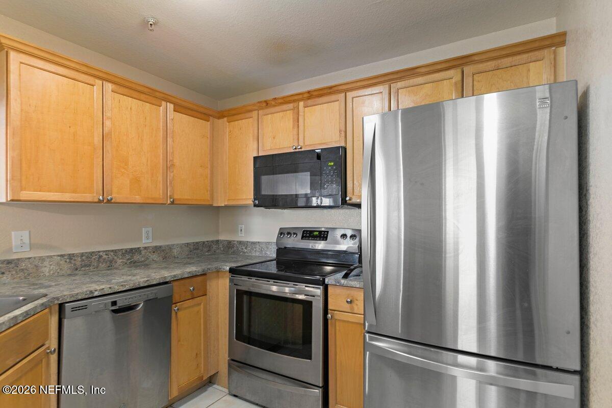 10961 Burnt Mill Road, Unit 333 Jacksonville, FL 32256 - Photo 5 of 21 a kitchen with stainless steel appliances granite countertop a refrigerator stove and sink