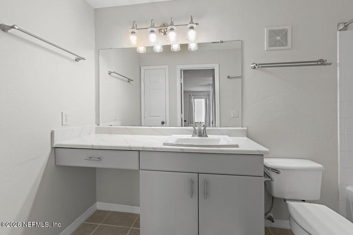 10961 Burnt Mill Road, Unit 333 Jacksonville, FL 32256 - Photo 8 of 21 a bathroom with a toilet a sink and mirror