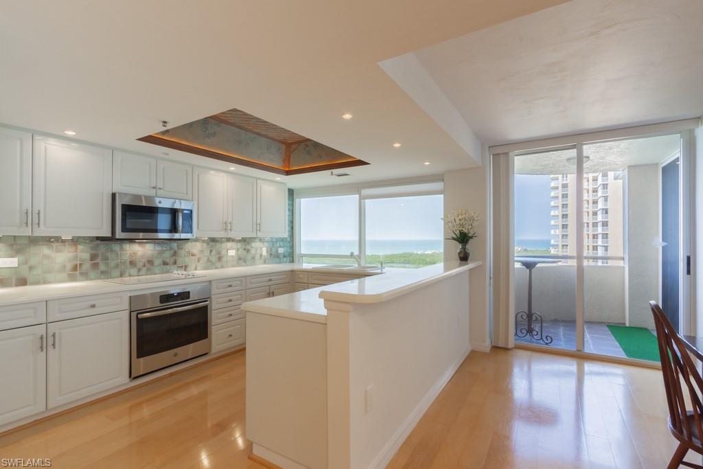 6825 Grenadier Boulevard, Unit 1505 Naples, FL 34108 - Photo 11 of 35 a large kitchen with cabinets and stainless steel appliances