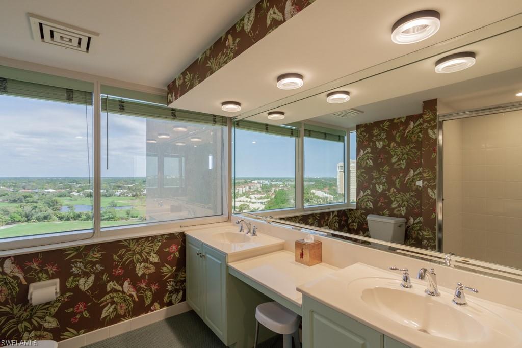 6825 Grenadier Boulevard, Unit 1505 Naples, FL 34108 - Photo 28 of 35 a bathroom with a double vanity sink and large mirror