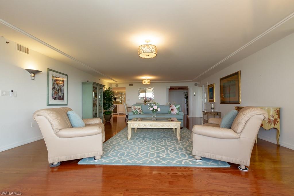 6825 Grenadier Boulevard, Unit 1505 Naples, FL 34108 - Photo 7 of 35 a living room with furniture and a wooden floor