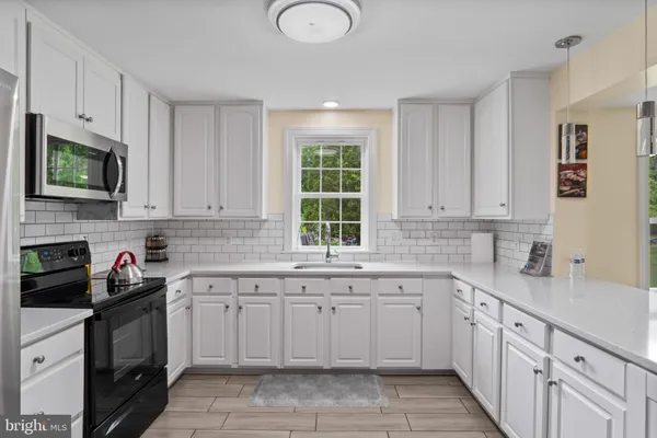 a kitchen with cabinets appliances a sink and a window