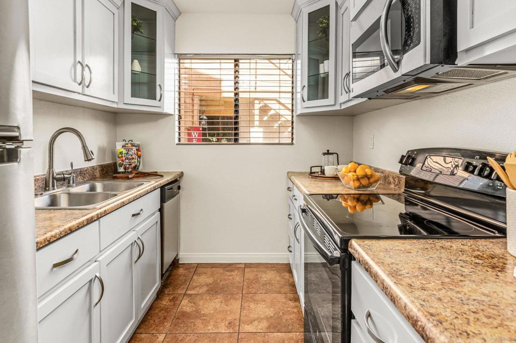 2920 Briarwood Road, Unit I1 Bonita, CA 91902 - Photo 6 of 24 a kitchen with stainless steel appliances granite countertop a stove and a sink