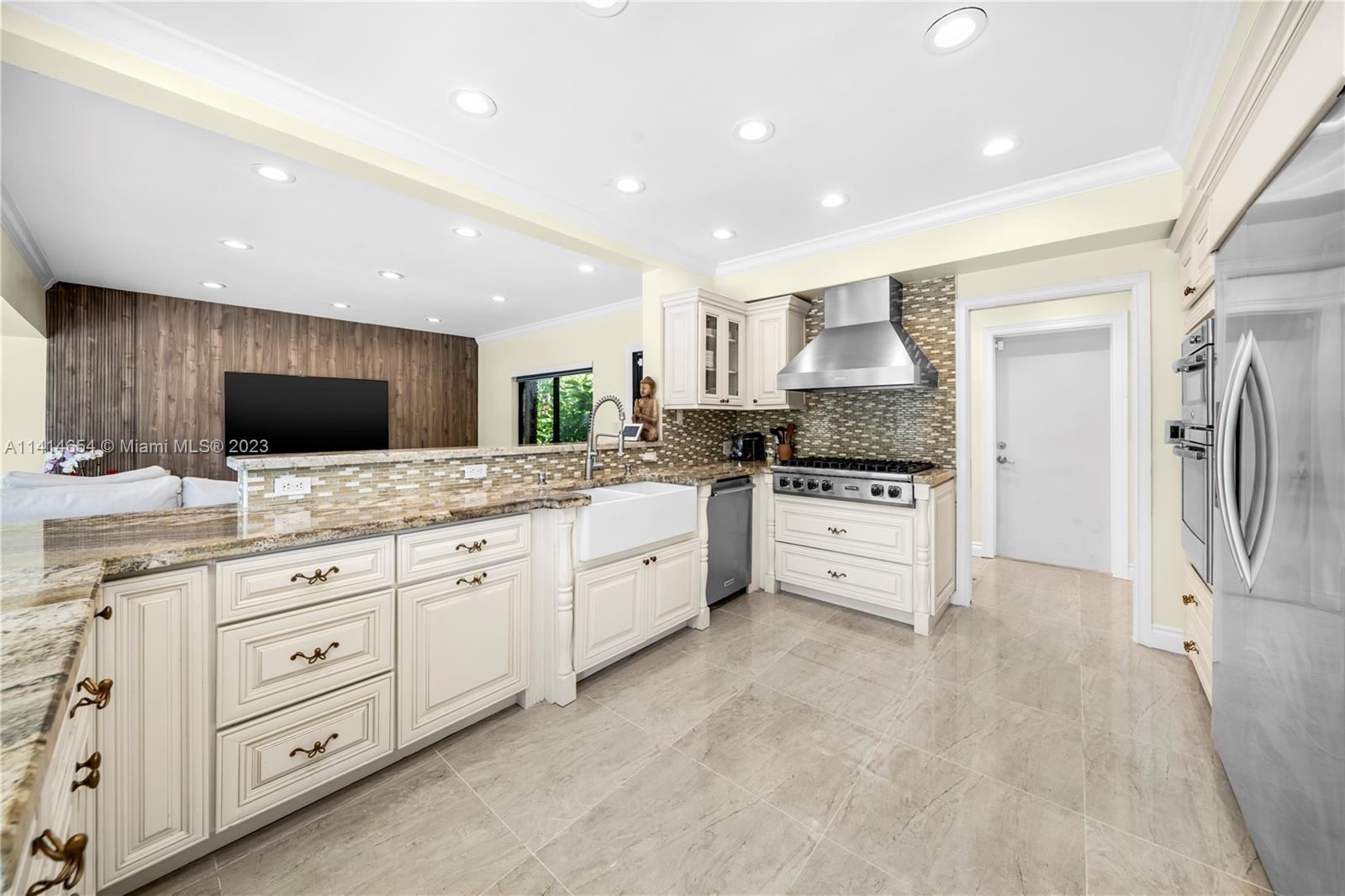 1160 Northeast 91st Street Miami, FL 33138 - Photo 11 of 33 a large kitchen with stainless steel appliances kitchen island granite countertop a stove a sink and a refrigerator