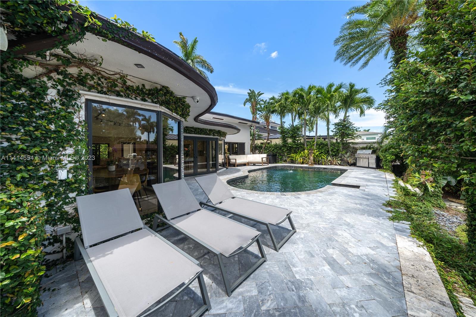 1160 Northeast 91st Street Miami, FL 33138 - Photo 28 of 33 a view of a patio with table and chairs potted plants and palm tree