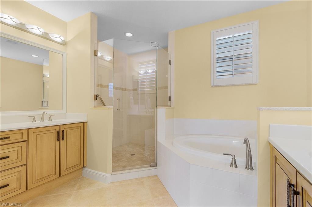 801 Regency Reserve Circle, Unit 4301 Naples, FL 34119 - Photo 12 of 26 a bathroom with a bathtub sink and mirror