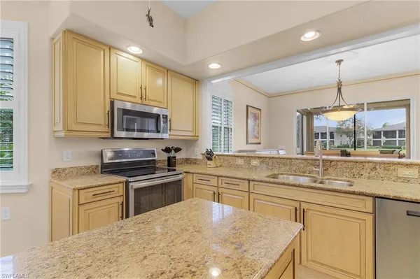 a kitchen with stainless steel appliances granite countertop a sink stove and microwave
