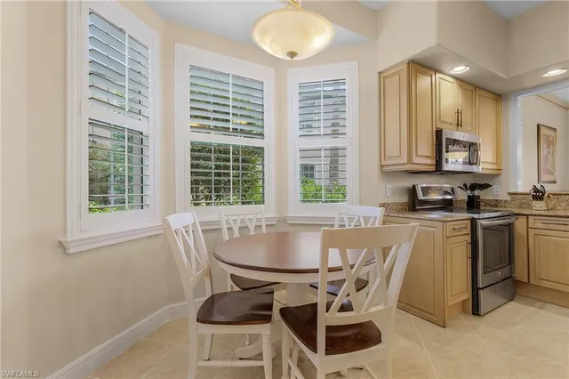 a kitchen with a table chairs cabinets and a window