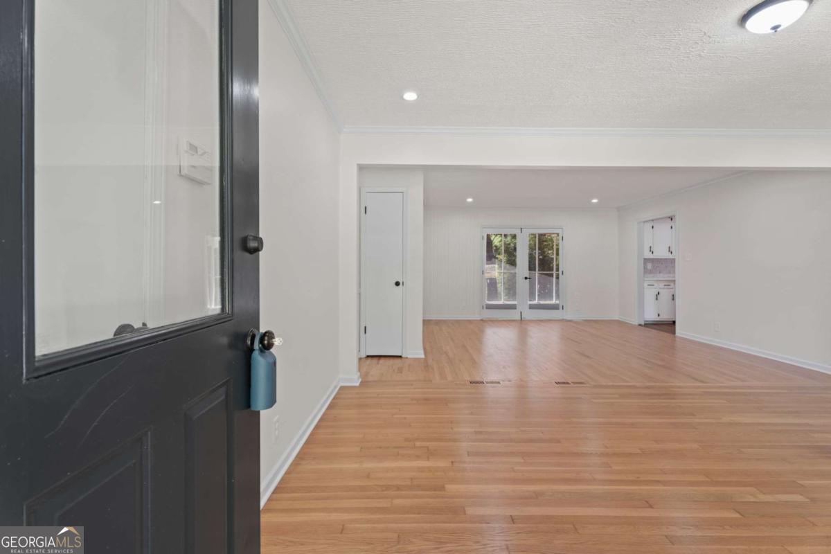 865 Old Tucker Road Stone Mountain, GA 30087 - Photo 6 of 57 a view of an empty room with wooden floor and kitchen