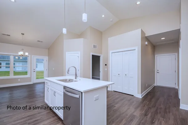 a kitchen with a sink cabinets and wooden floor