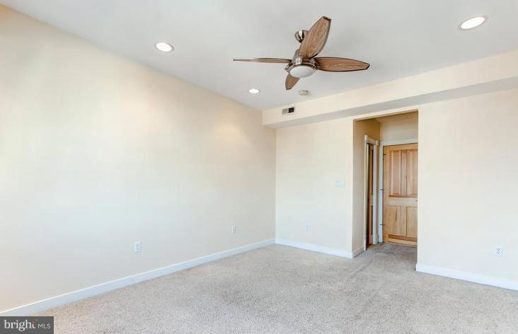 3403 Dillon Street Baltimore, MD 21224 - Photo 11 of 30 an empty room with a ceiling fan and carpet