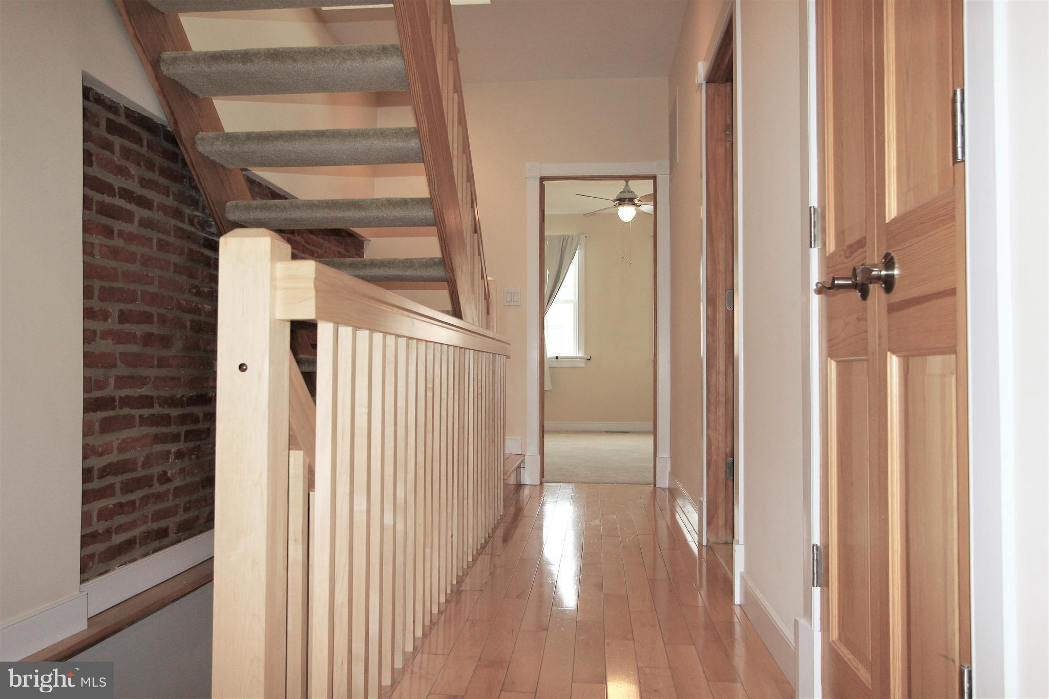 3403 Dillon Street Baltimore, MD 21224 - Photo 19 of 30 a view of a hallway with wooden floor and staircase