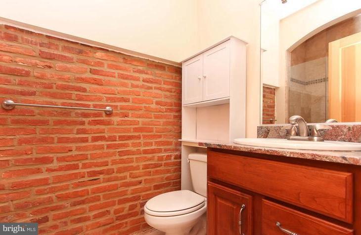 3403 Dillon Street Baltimore, MD 21224 - Photo 20 of 30 a bathroom with a granite countertop sink mirror vanity and toilet