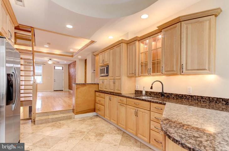 3403 Dillon Street Baltimore, MD 21224 - Photo 2 of 30 a kitchen with stainless steel appliances granite countertop a sink and cabinets