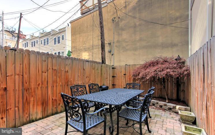 3403 Dillon Street Baltimore, MD 21224 - Photo 27 of 30 a view of a patio with table and chairs and wooden floor
