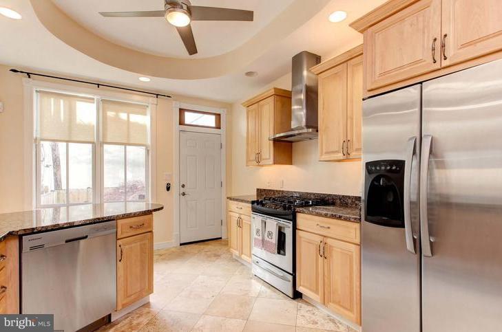 3403 Dillon Street Baltimore, MD 21224 - Photo 4 of 30 a kitchen with stainless steel appliances granite countertop a stove a refrigerator and a refrigerator