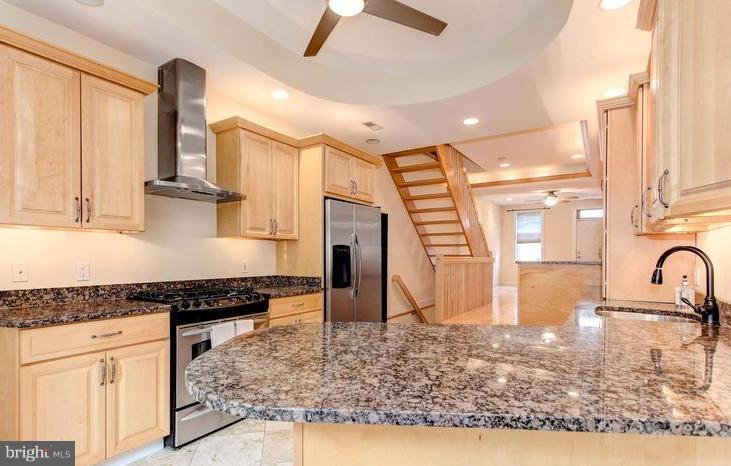 3403 Dillon Street Baltimore, MD 21224 - Photo 5 of 30 a kitchen with stainless steel appliances granite countertop a sink a stove and a refrigerator