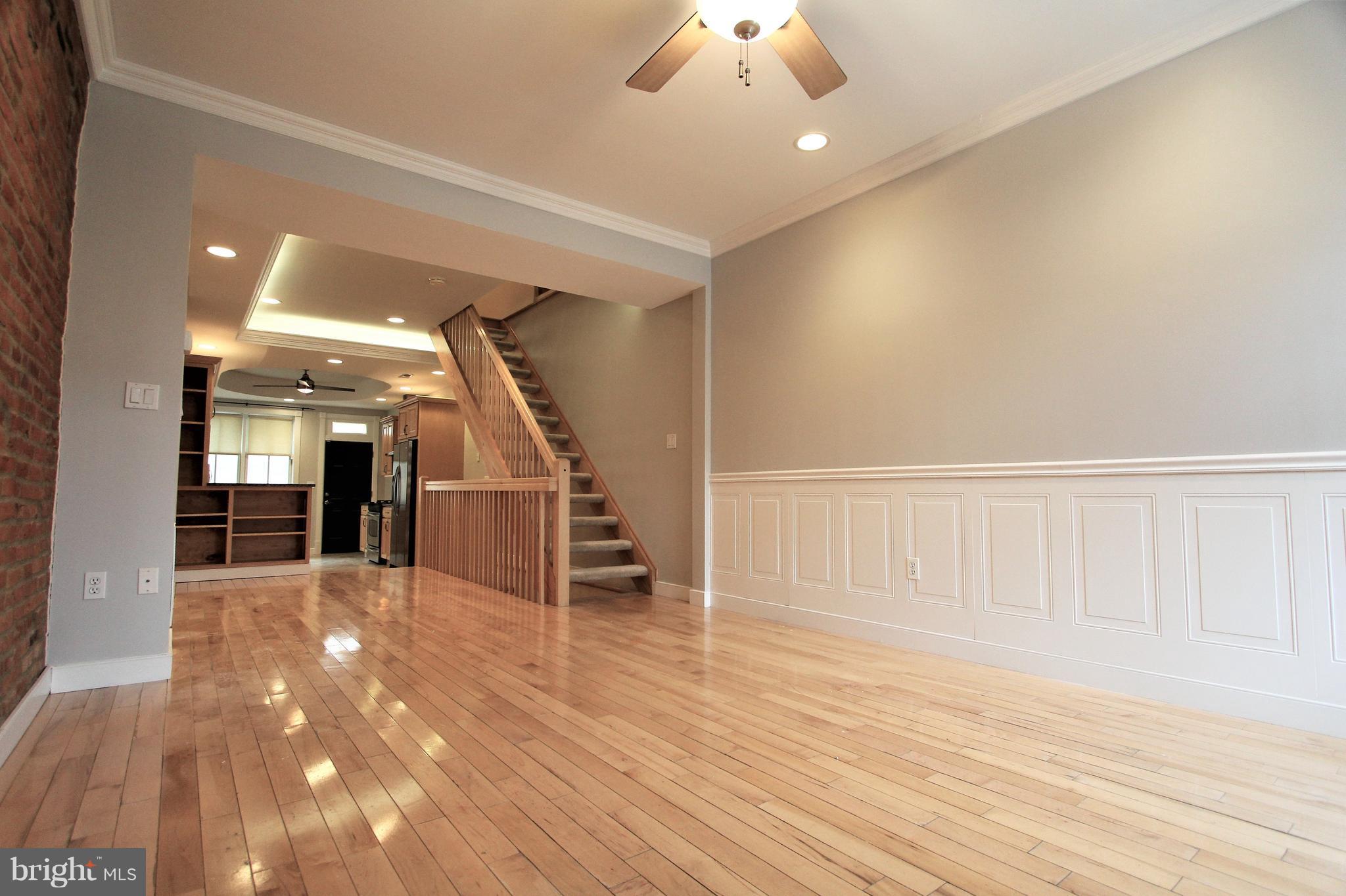 3403 Dillon Street Baltimore, MD 21224 - Photo 8 of 30 en empty room with wooden floor chandelier and entryway