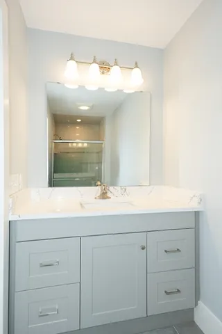 a bathroom with a sink vanity and mirror