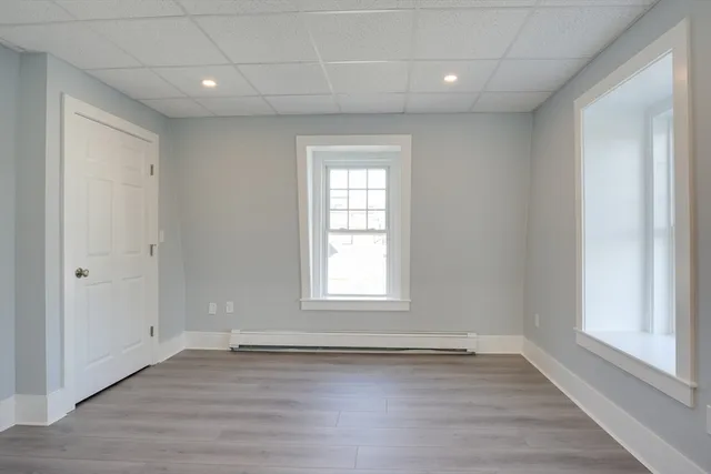an empty room with wooden floor and window
