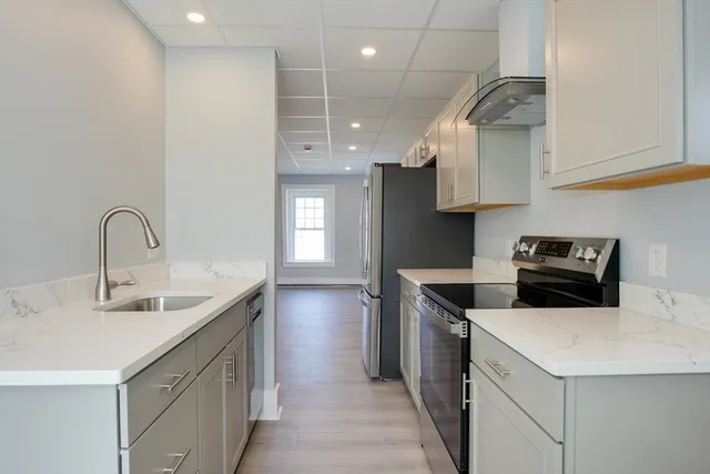 a kitchen with stainless steel appliances a sink a stove and a refrigerator