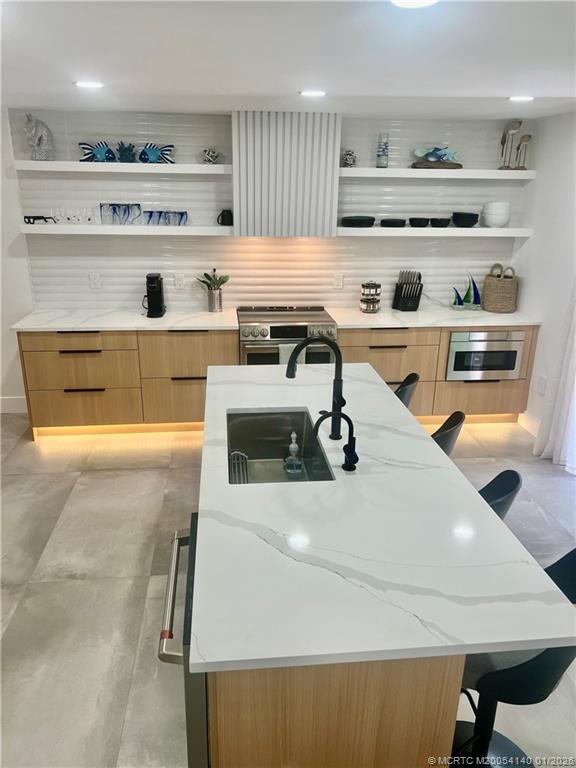 a kitchen with a sink a stove and chairs