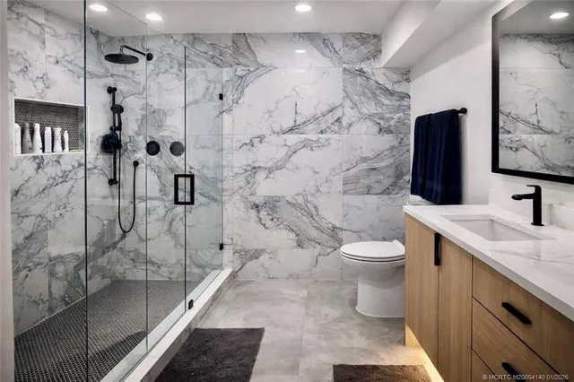 a bathroom with a granite countertop sink toilet and shower