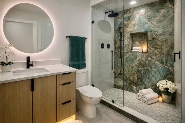 a bathroom with a sink a toilet and shower