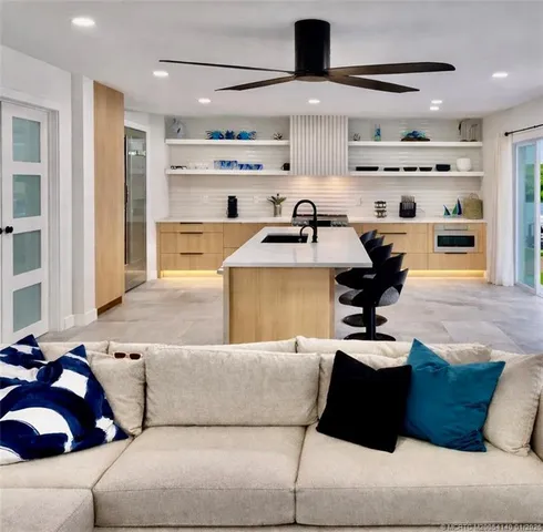 a living room with furniture and a view of kitchen appliances